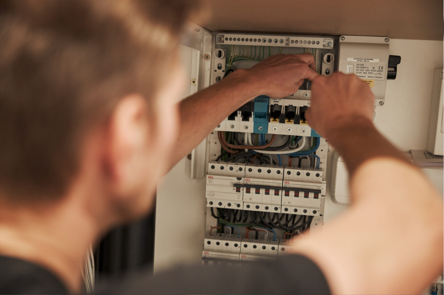 Billig elektriker arbejder i gruppetavle, sikker el-installation